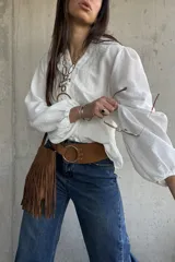 Camisa blanca de manga larga abullonada, con delicados bordados frontales y cierre con botones.