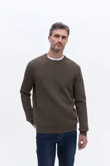 Sweater de cuello redondo con textura de tejido marcado, manga larga y puños acanalados.