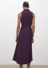 Vestido midi color borravino, sin mangas, con cuello camisero, cierre frontal con botones y cinturón ajustable del mismo tejido.