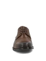 Zapato formal de cuero en color marrón coñac, estilo Oxford con cordones, punta redondeada con costura en la puntera y suela con tacón bajo.