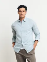 Camisa sport de manga larga con cuello buttondown, confeccionada en una mezcla de algodón y lino. Presenta un diseño clásico en color celeste con cierre frontal de botones.