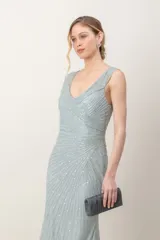 Vestido largo de tul color verde agua, enteramente bordado con lentejuelas, con escote en V cruzado y corte imperio.