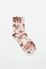 Par de medias de caña media con estampado tie dye en tonos marrones y blancos.