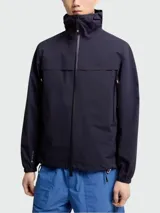 Campera impermeable Moncler Grenoble modelo Shipton, de color azul marino, con capucha alta, cierre frontal termo sellado, bolsillos laterales con cremallera y puños elásticos.