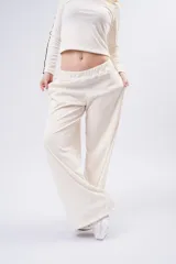 Pantalón tipo palazzo de corte amplio y fluido, color negro, con doble línea lateral blanca y cintura elástica.