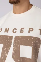 Remerón de corte oversize con cuello redondo y mangas cortas. Presenta un diseño estampado frontal con la palabra 'CONCEPT' y el número '78' en efecto desgastado, además de dos franjas horizontales en las mangas.