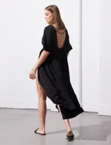 Kaftan de color blanco con apliques de puntilla en el escote y la cintura. Presenta una abertura central con lazo para atar, mangas cortas amplias y un diseño fluido de marca Barrington.