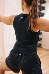 Top deportivo sin mangas color lila, de cuello alto y corte ajustado.