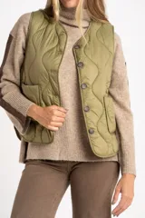 Chaleco acolchado color verde oliva, con diseño capitoneado de ondas, cierre frontal con botones y bolsillos laterales.