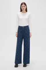 Pantalón de jean azul con estampado de lunares, tiro alto, pinzas en la cintura y corte ancho.