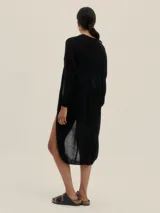 Cárdigan largo tejido en jersey color negro, con bolsillos delanteros y detalle de logo en cobre.