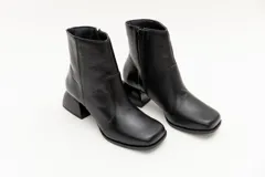 Botas cortas de cuero negro, con punta cuadrada y cierre lateral.