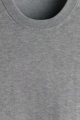 Buzo de punto fino con cuello redondo y diseño de corte estándar. Presenta terminaciones acanaladas en el cuello, los puños y el ruedo.