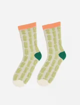 Par de medias de caña media con textura en relieve, diseño de patrón geométrico en color verde sobre fondo crema, con puño superior en color naranja y talón en color verde oscuro.