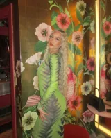 Vestido midi ajustado de microtul verde con estampado abstracto en tonos oscuros. De mangas largas y cuello redondo, es una prenda transparente y elástica.