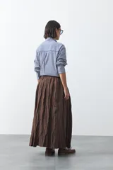 Falda larga de silueta amplia y caída fluida, con cintura elástica y textura arrugada.