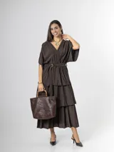 Vestido midi de crepé color marrón, con escote en V, mangas cortas amplias, cintura elastizada con lazo ajustable y falda larga escalonada con volados.