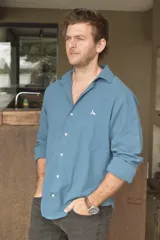 Camisa celeste de lino con cuello clásico, manga larga con puños abotonados y cierre frontal con botones.