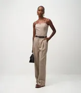 Pantalón de sastrería color beige con rayas verticales finas, de corte wide leg. Incluye un cinturón de cuero sintético marrón con hebilla metálica.