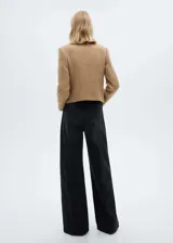 Chaqueta de corte recto confeccionada en tejido tweed con mezcla de lana. Presenta cuello de tira, cierre frontal con botones, manga larga y cuatro bolsillos delanteros con solapa y botón. Incluye forro interior.