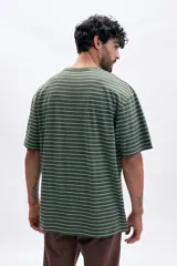 Remera de corte oversize con cuello redondo y mangas cortas, presenta un diseño de rayas horizontales finas en color verde y blanco.