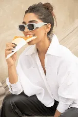 Camisa oversize de lino, color blanco, con cuello camisero clásico, cierre frontal con botones y puños con detalle de tablitas.