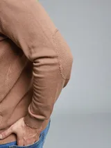 Remera tejida gris con cuello alto y medio cierre.