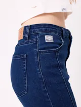 Jean de corte recto con costuras verticales decorativas en el frente, tiro medio y cierre frontal con botón metálico.