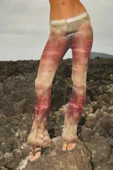 Pantalón de tul con estampado abstracto en tonos tierra, rojo y verde. Tiene elástico en la cintura y corte acampanado.