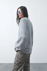Sweater de punto con textura tramada, color azul marino, de silueta relajada y mangas abullonadas con puños ajustados.