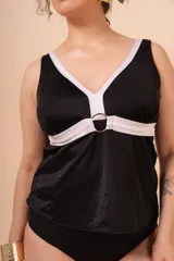 Camiseta tankini negra con escote en V, vivos blancos en contraste y aplique de aro metálico en el cinto. Incluye bolsillo interno en el busto para colocar copa removible o prótesis externa.