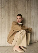 Pantalon de corte recto y tiro medio en color beige, con detalle de rayas laterales verticales en contraste blanco. Cuenta con cintura elástica y bolsillos laterales.