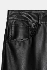 Pantalón de tiro medio con diseño tipo ballon, confeccionado en material efecto piel. Cuenta con cinco bolsillos, cierre frontal con cremallera y botón metálico.