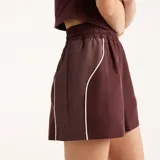Short New Balance de felpa francesa, color bordó, con cintura elástica, ribetes en contraste y logotipo bordado en el muslo izquierdo.