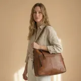 Bolso tipo tote color marrón confeccionado en eco-cuero suave con textura premium. Incluye monedero a juego, cierre superior seguro y bolsillos internos.