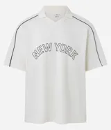 Remera tipo polo de hombre, color blanco crudo, con escote en V ribeteado en negro y ribetes negros en las costuras de los hombros. Presenta la inscripción arqueada "NEW YORK" en negro en el pecho.
