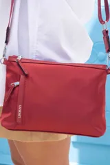 Bandolera morral color rojo, con cierre principal, bolsillo frontal horizontal y bolsillo dorsal. Incluye correa de galón a tono con la marca "Lincoln's" grabada.