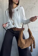 Remera blanca de manga larga con detalles bordados de flores en marrón en la parte superior frontal.