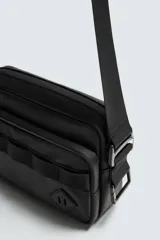 Bandolera negra de acabado engomado con compartimento principal con cierre de cremallera y bolsillo interior plano. Bolsillo frontal con cierre de cremallera. Asa de hombro ajustable y extraíble.