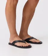 Sandalias de dedo para hombre, confeccionadas en material sintético con tiras anchas, diseño limpio, suela plana y acabado uniforme.