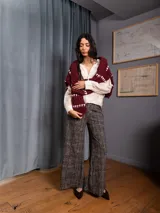 Pantalon palazzo de tiro alto con estampado de espiga en tonos negro y beige. Presenta corte amplio, bolsillos laterales y presillas para cinturón.