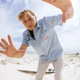 Camisa celeste de manga corta, con dos bolsillos frontales y logo bordado en el pecho.