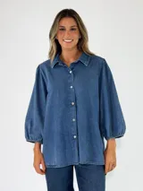 Camisa de denim azul de corte holgado y diseño oversize, con mangas largas abullonadas, puños elásticos y cierre frontal con botones.