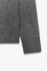 Jersey de punto liso color verde, con cuello redondo y manga larga. Confeccionado en lana suave.