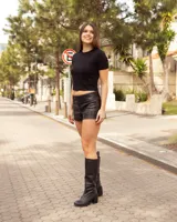 Bota de caña alta de cuero color negro, de diseño clásico con taco ancho y puntera redondeada.