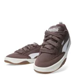 Championes Puma de estilo urbano inspirados en el skate, con perfil bajo. Presentan una estructura combinada de material sintético y superposiciones de gamuza en color negro, con el icónico logo de la marca en blanco en el lateral. Cuentan con cordones gruesos en color crema, entresuela blanca y suela de goma color caramelo.
