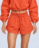 Short de poliéster y poliamida color naranja, de cintura clochard con regulador y ajustes laterales con cordón. Cuenta con bolsillos laterales.