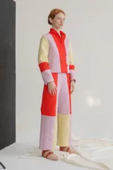 Pantalón de corte recto y tiro alto, confeccionado en tela capitoneada con un diseño de bloques de color en tonos rojo, lila y amarillo. Cuenta con cierre trasero.