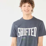 Camiseta azul de manga corta con estampado frontal de la palabra "SHIFTED" en blanco y texto en verde.