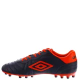 Championes de fútbol 11 Umbro modelo Touch AT, color negro con detalles en naranja vibrante. Presentan el logo de la marca en el lateral, cordones naranjas y suela con tapones para césped.